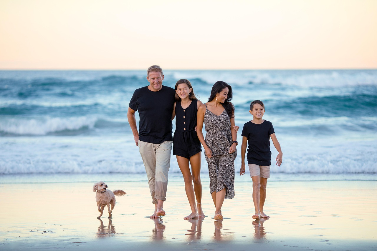 Família feliz na praia - Proteção e cuidado para toda família